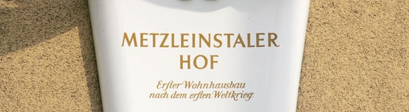 Ein Foto der Tafel des ersten Wiener Gemeindebaus, des Metzleinstalerhofs.